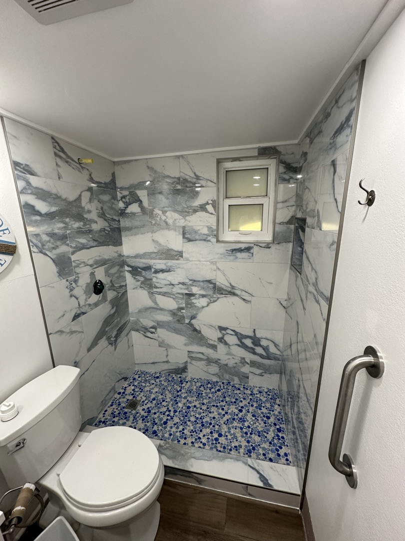 Marble look porcelain shower with pebble floor