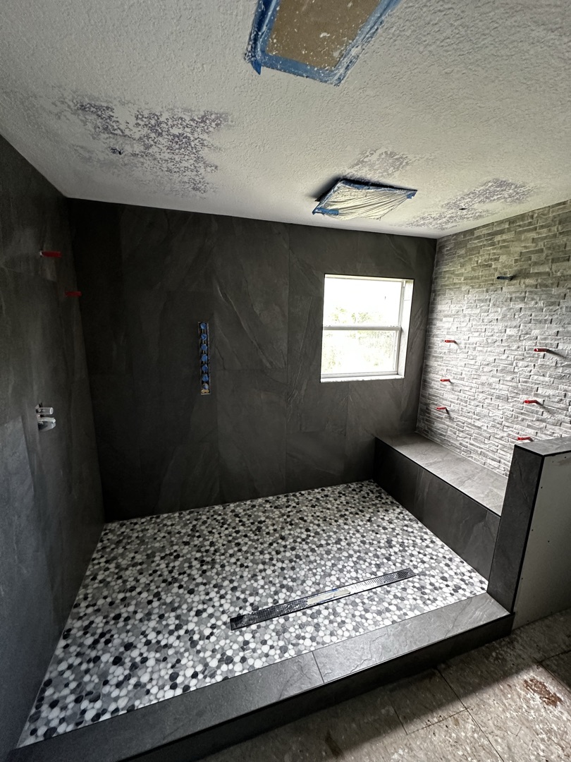Blue marble walk-in shower with decorative pebble floor