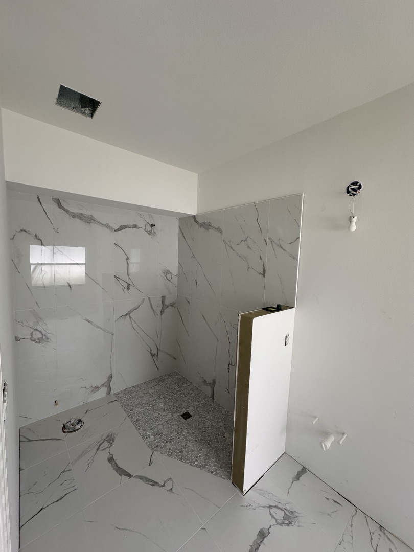 Large custom shower with glass enclosure and pebble floor