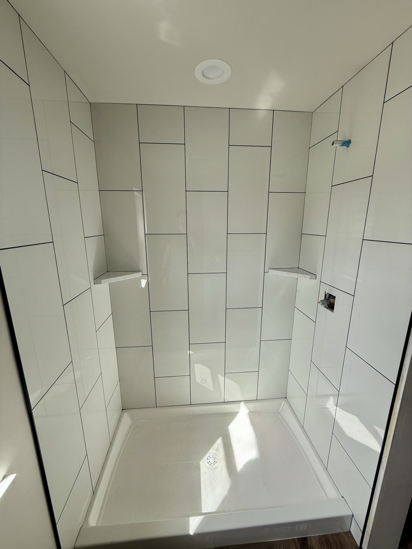 White vertical tile shower with built-in niches