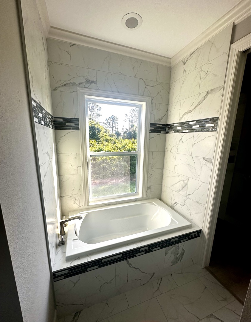 Marble bathtub surround with mosaic accent by Tilesmith AK