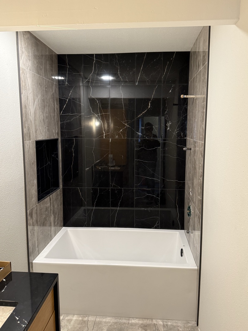 Black marble bathtub surround with built-in niche