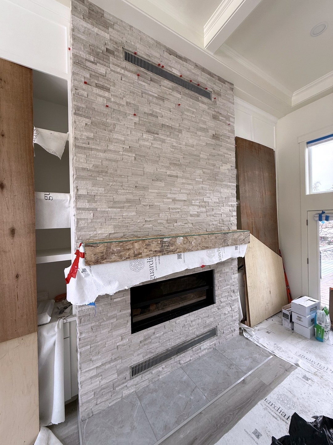 Floor-to-ceiling stacked stone fireplace surround