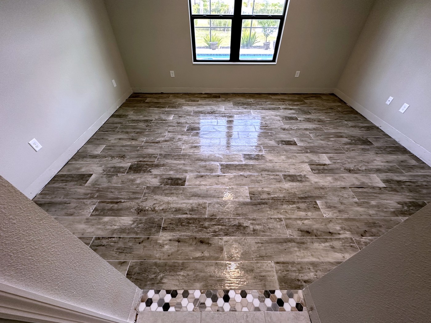 Wood-look plank tile floor with mosaic transition